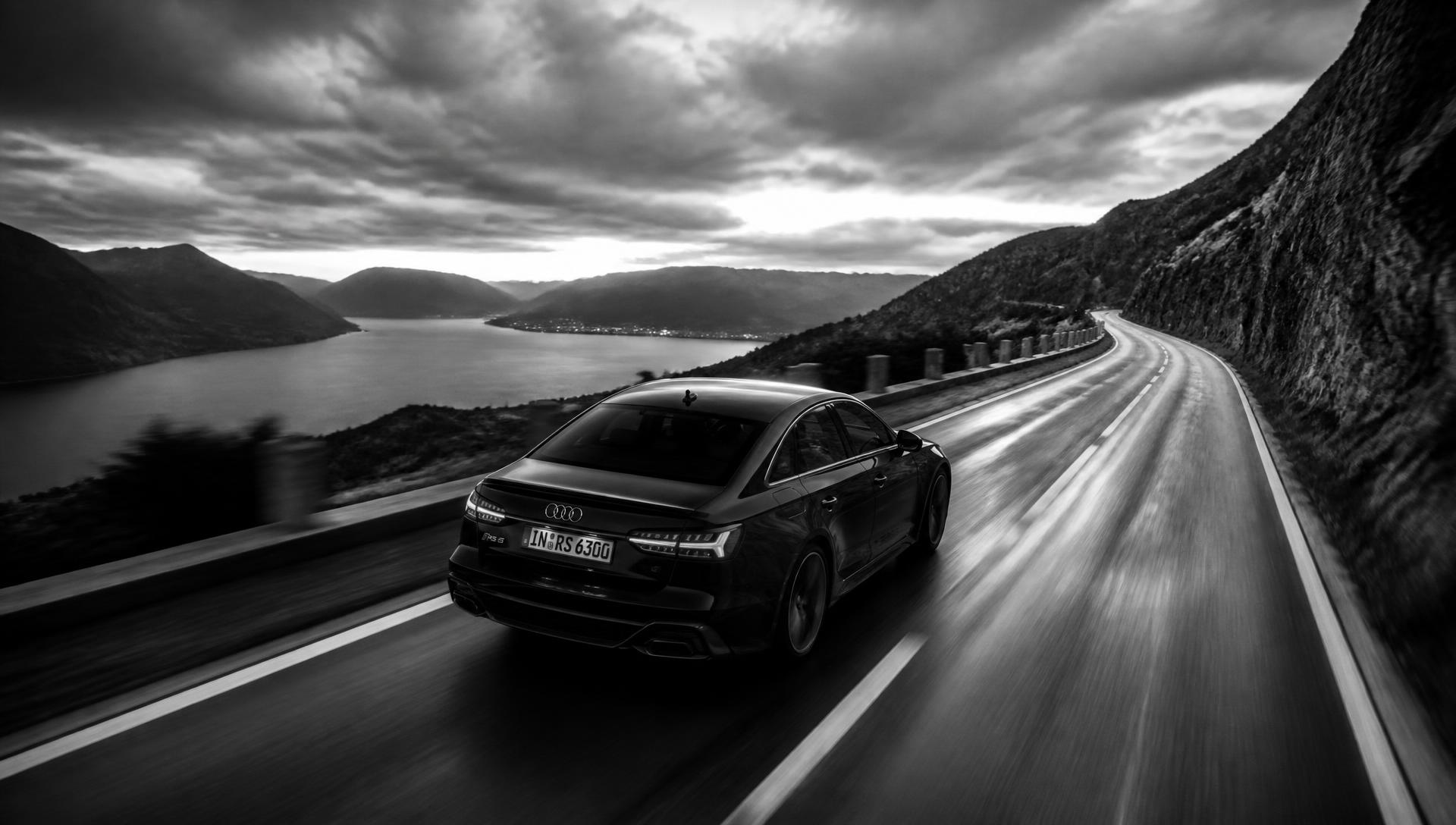 Audi nera ripresa da drone mentre corre su una strada di montagna